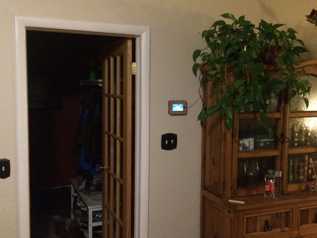 The iPhone 5 frame mounted next to the raspberry pi in our living room, and its USB power cable is plugged into the rpi.